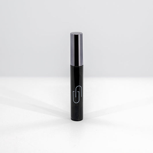 Black mascara tube with silver cap on a white background